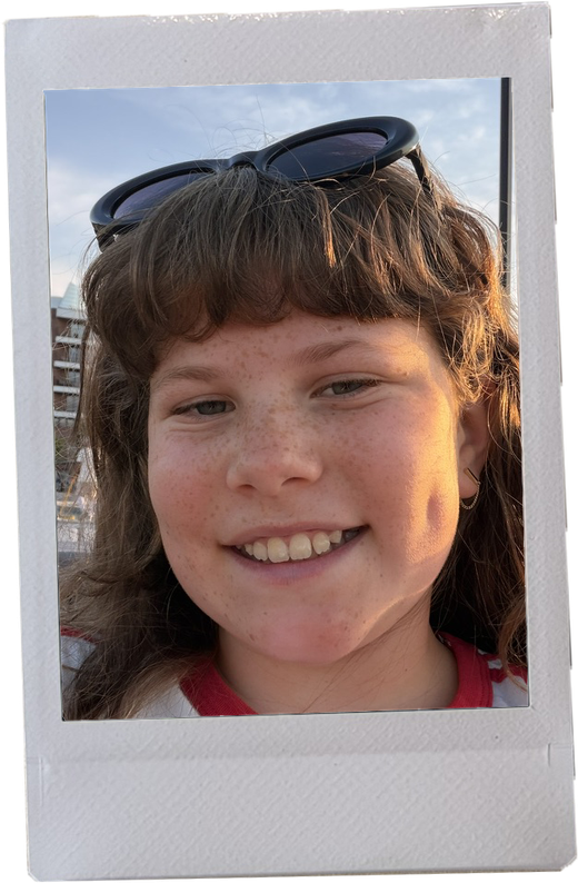 Flora smiling with sunglasses pushed up on her head