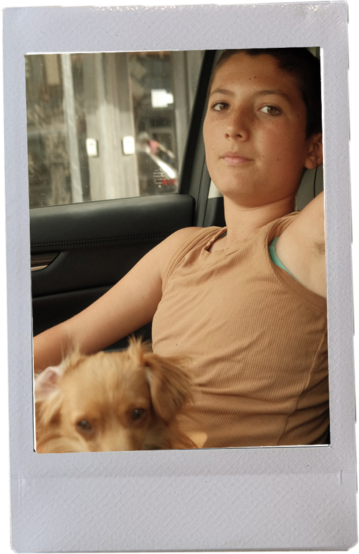 Orion sitting in the back seat of a car with a small tan dog in their lap