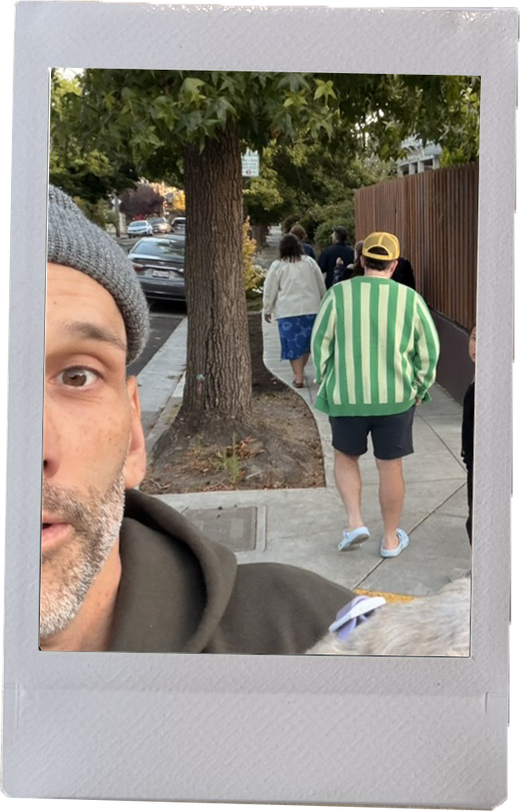 Alexis Madrigal in a gray beanie, taking a selfie on a tree-lined sidewalk