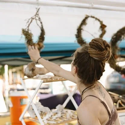 Gladys hanging her wreath in the E=MC2 booth