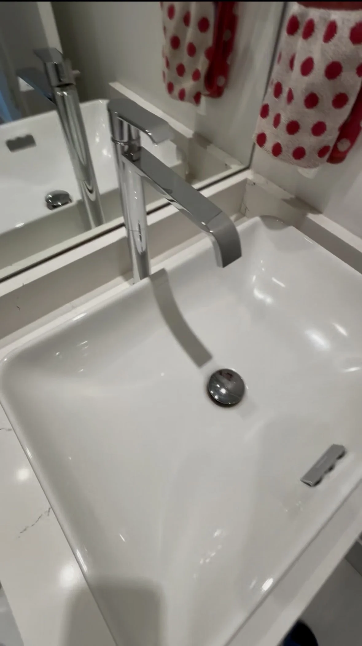 White bathroom sink gleaming and spotless, after cleaning