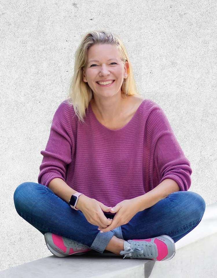 Denise Spekowius, Autorin von „Verkaufen ohne Kopfschmerzen“, entspannt im Schneidersitz vor heller Betonwand