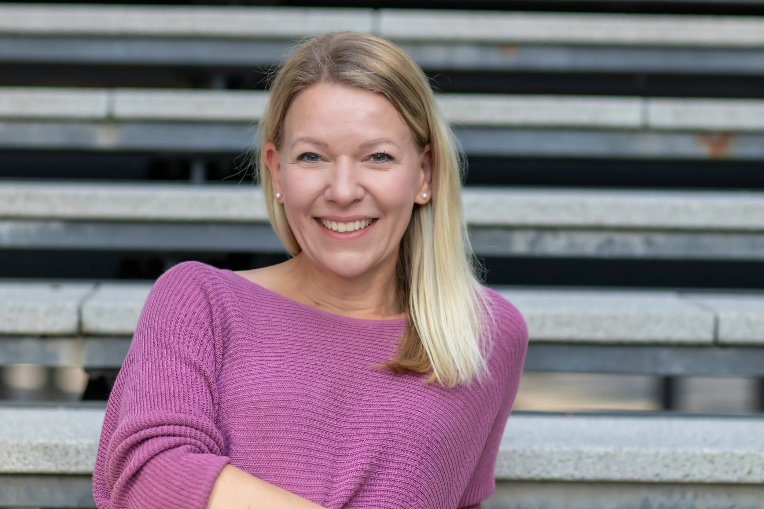 Denise Spekowius, Sales Coach, an einer Treppe lehnend