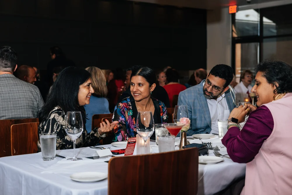Guests share conversation around a dinner table at Salum.