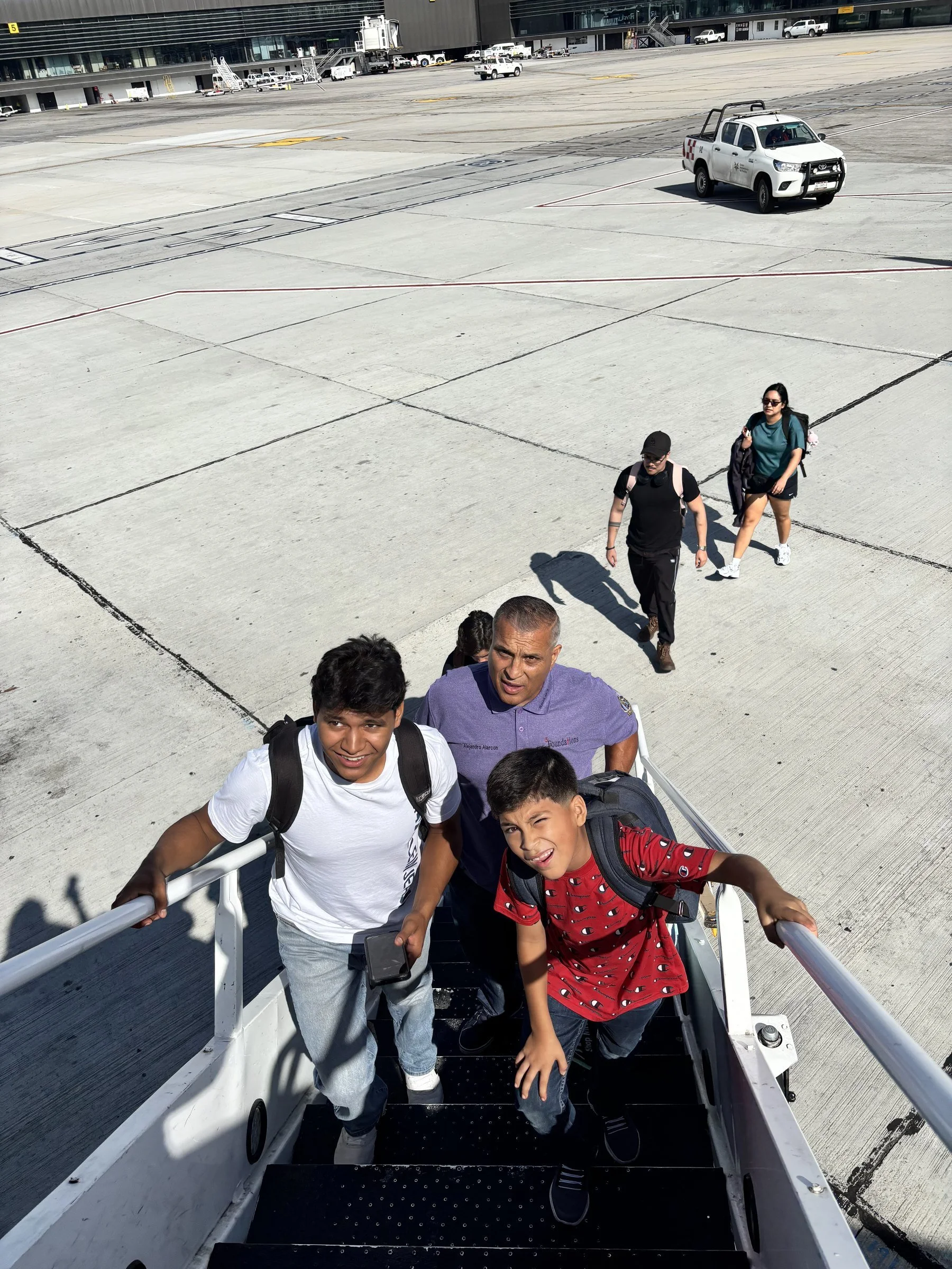 Volunteer team boarding aircraft stairs on arrival to Sinaloa field work