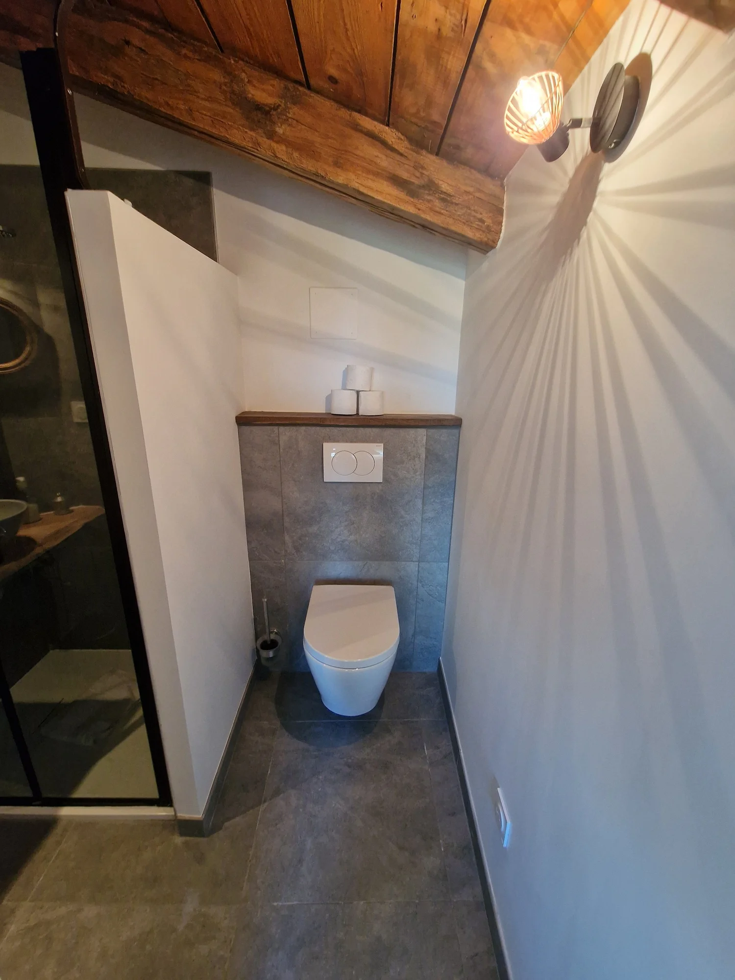 WC suspendu et éclairage rasant sur mur blanc – DõmHõ
