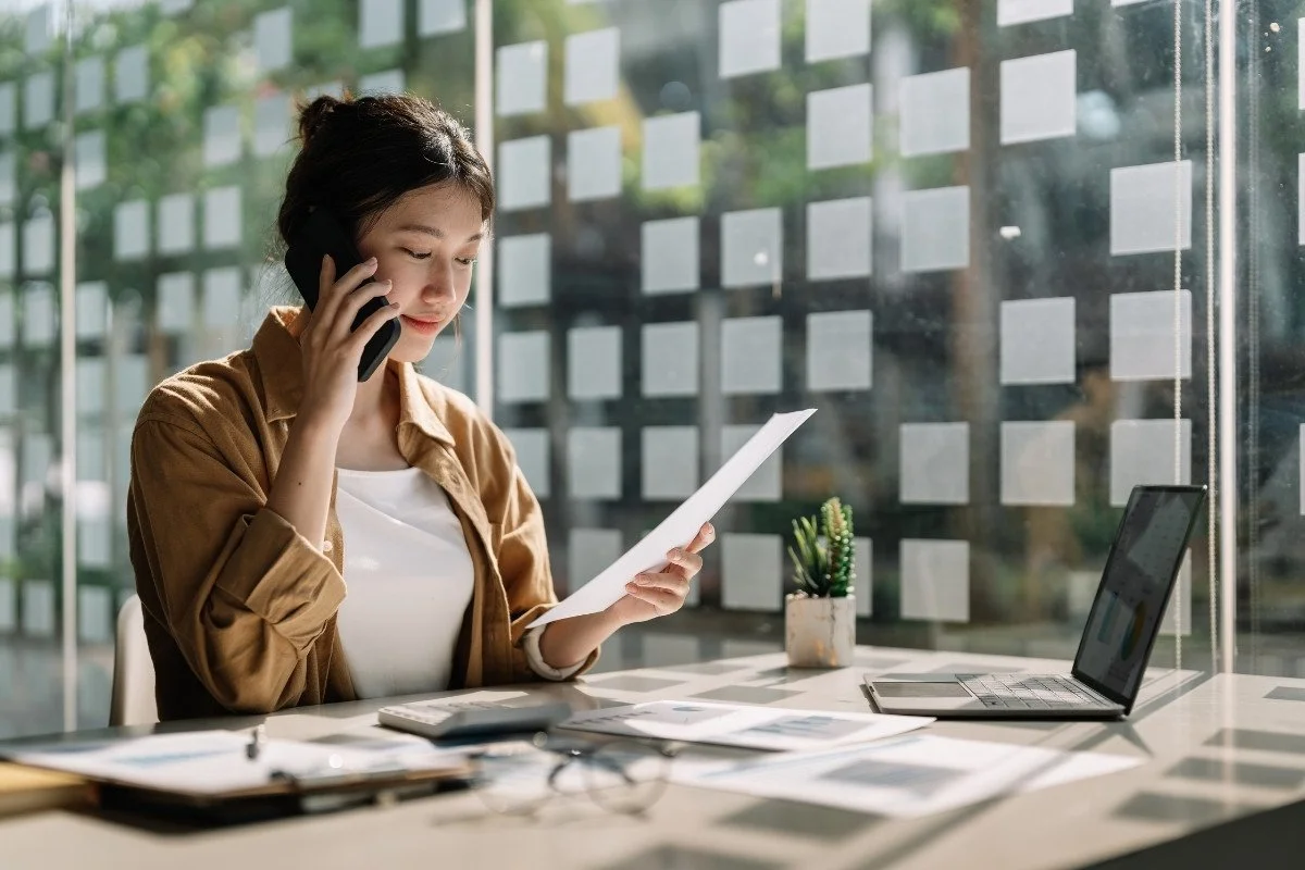 A Chinese business contact checking WeChat on her phone at her desk
