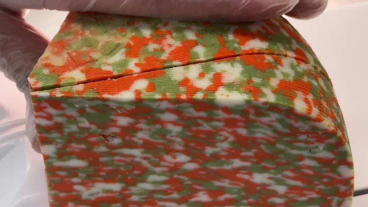 Gloved hands portioning Tricolore cheese in Auckland