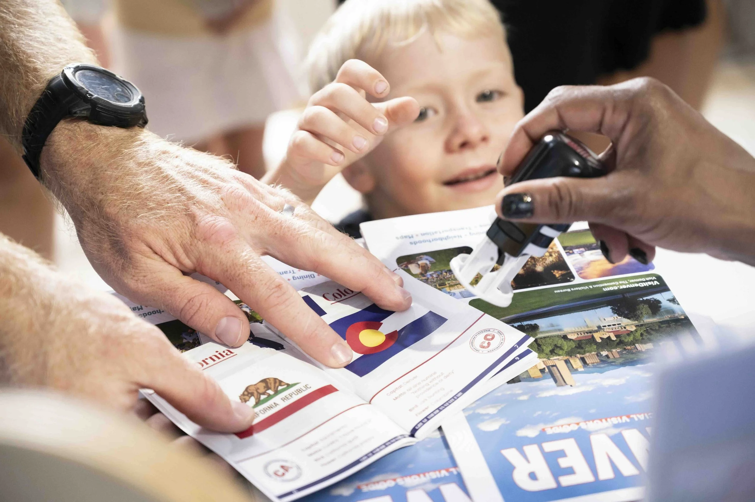 A young visitor exploring a Colorado travel guide