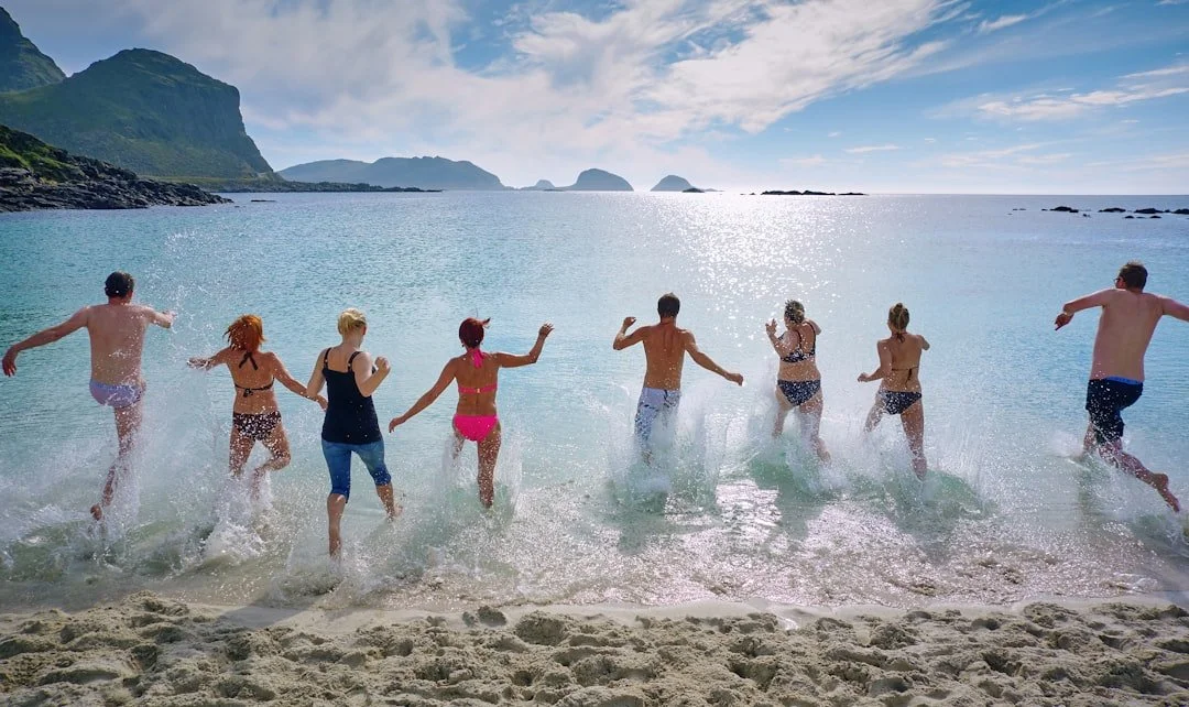 People running into the water at the beach