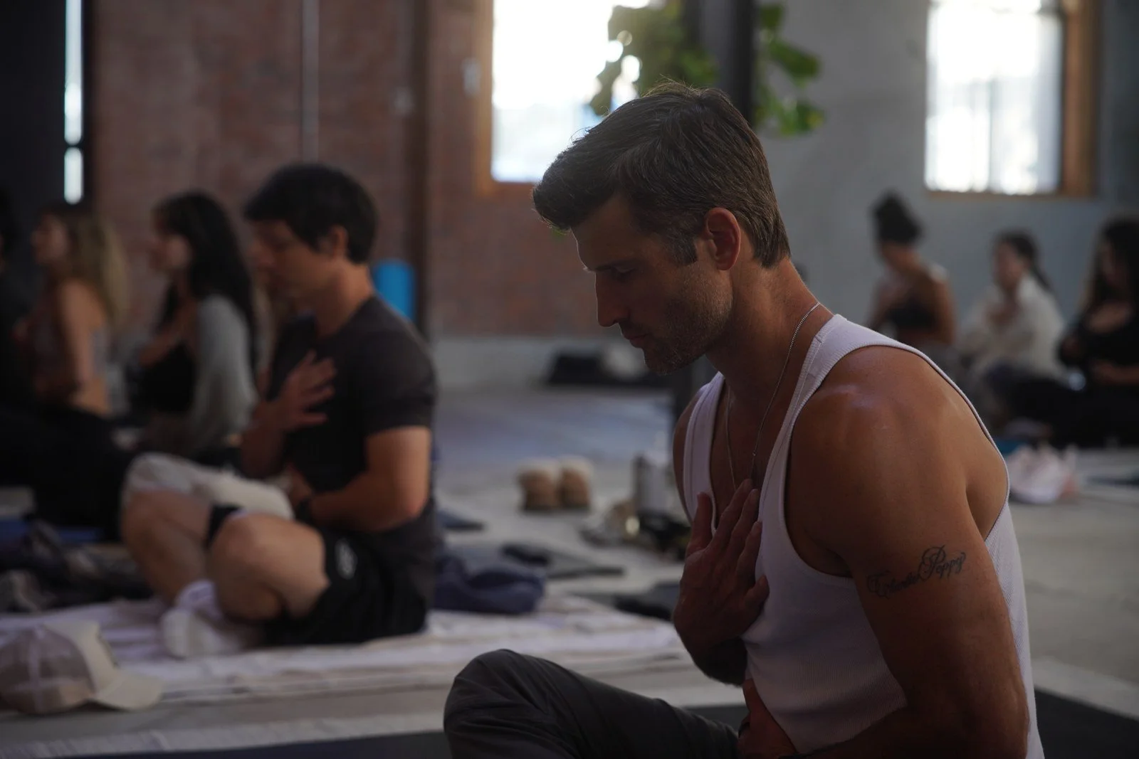 Members seated in a breathwork session, eyes closed, hands on chest