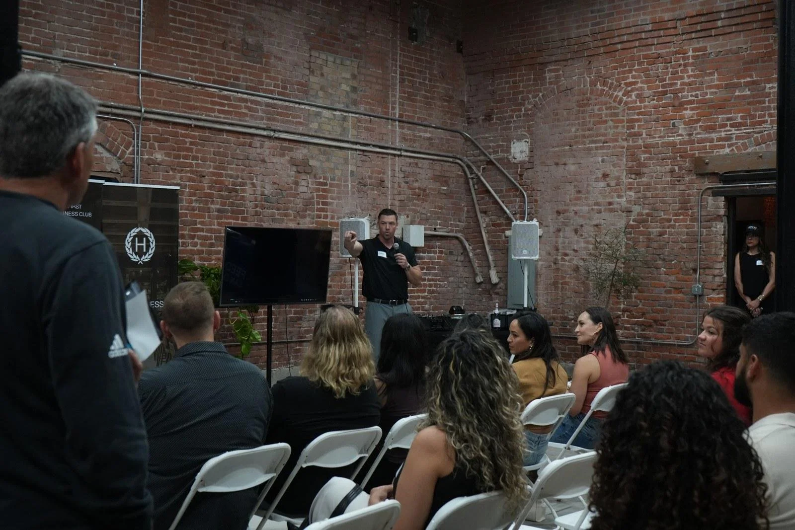 Speaker addressing a seated audience at a Heroic business club event