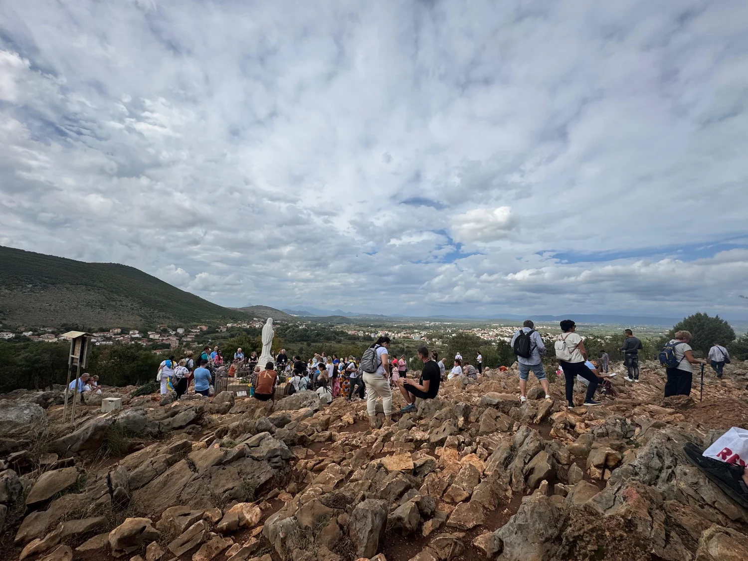 Pilgrims gathered on the rocks of Apparition Hill above Međugorje