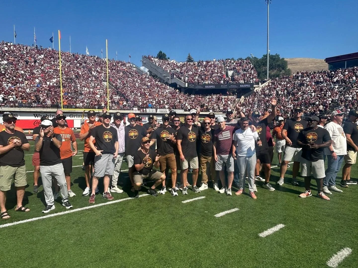 The 1995 Griz national championship team on the field at Washington-Grizzly Stadium in front of a full crowd