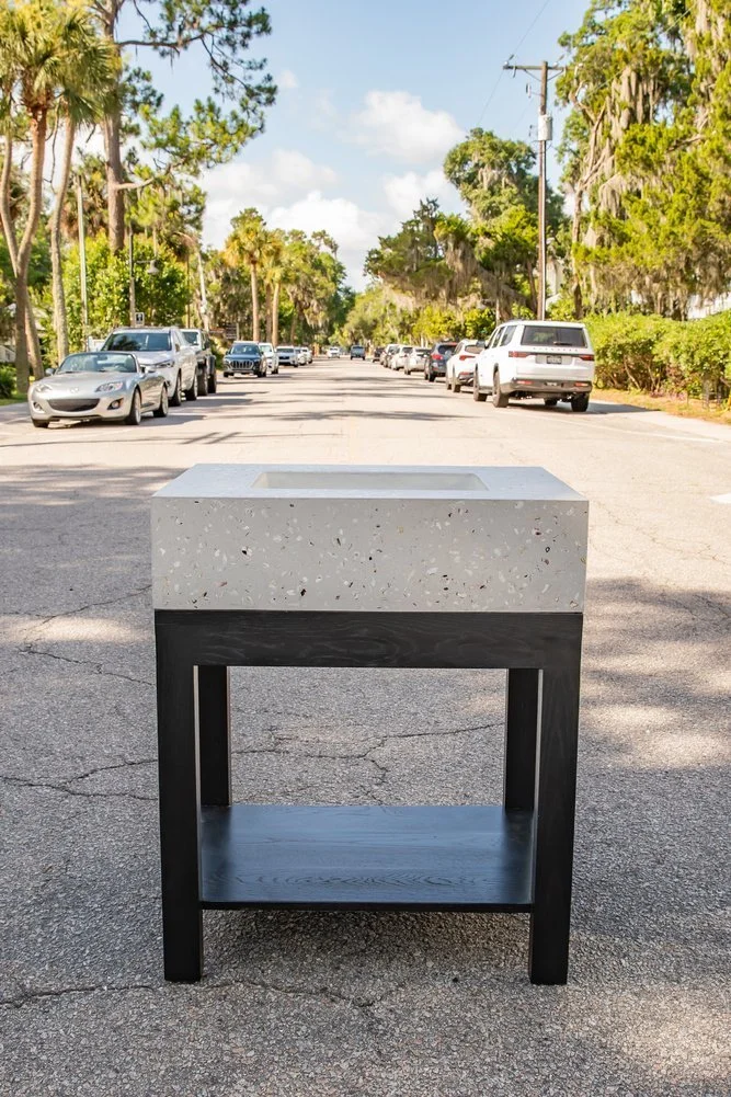 Light Shellstone Palmetto Block sink on a dark custom wood base outside Al and Harry’s Furniture