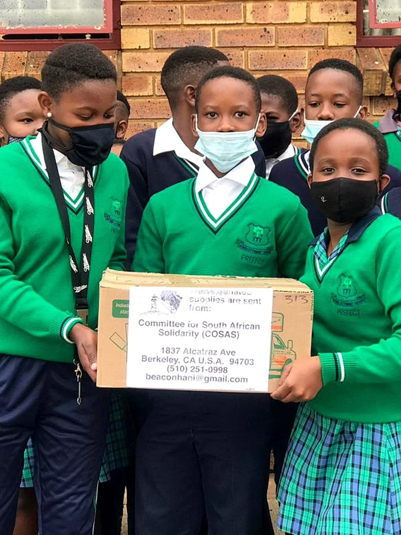 A group of young South African students holding boxes of supplies shipping by COSAS to their school in South Africa