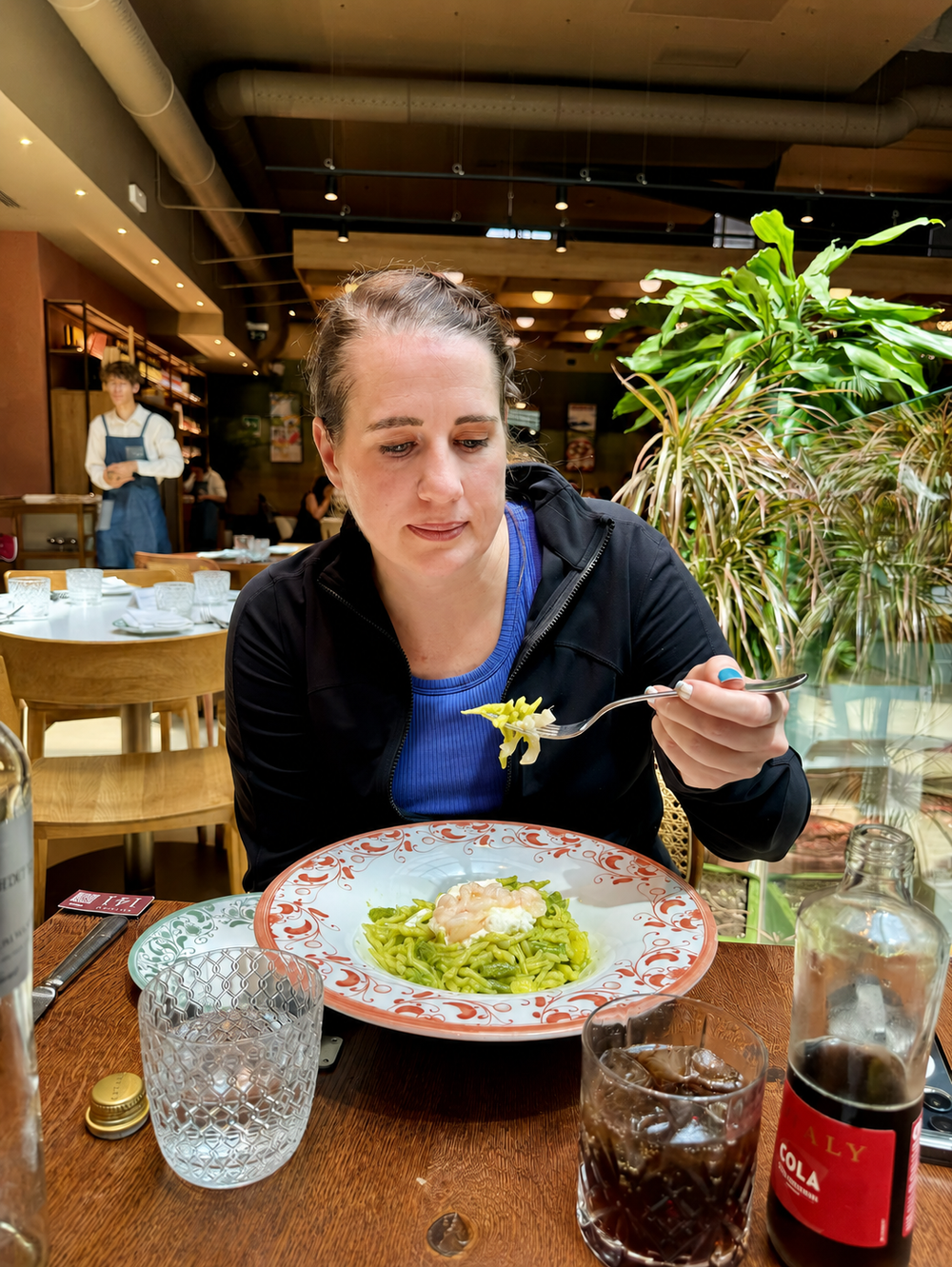 Traveler eating fresh pesto pasta with shrimp at Eataly Milano Smeraldo in Milan