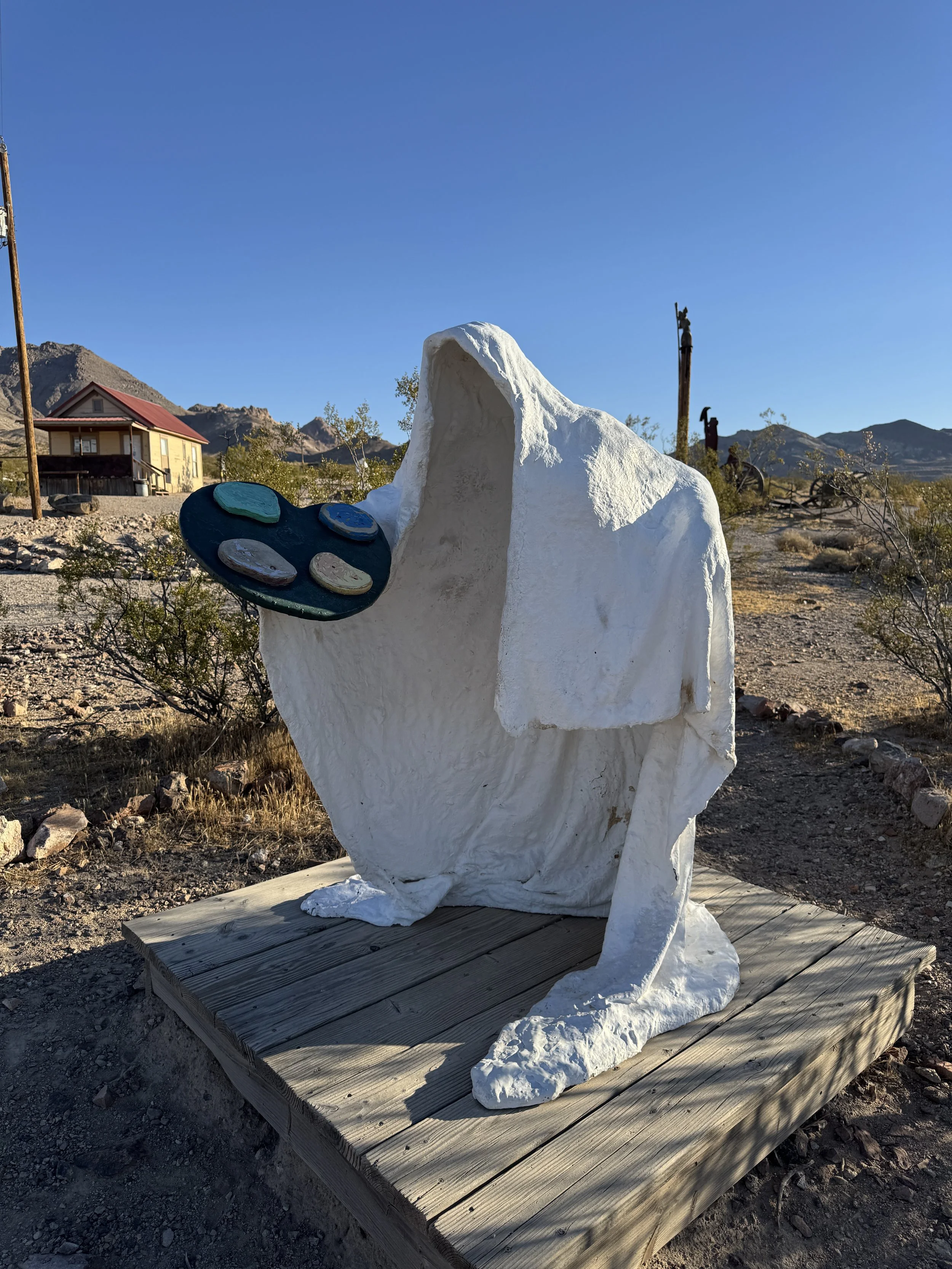 White shrouded artist sculpture holding a colorful paint palette at the Goldwell Open Air Museum.