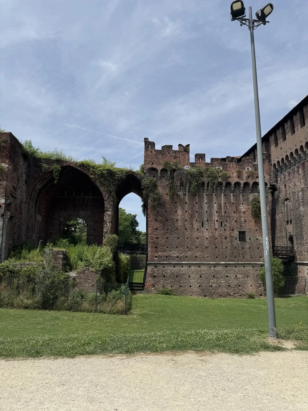 Medieval brick arches and fortified walls of Castello Sforzesco in Milan