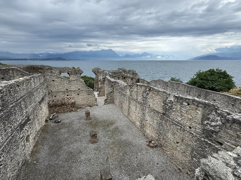 Stone walls of the Grotte di Catullo Roman ruins with Lake Garda and mountains beyond