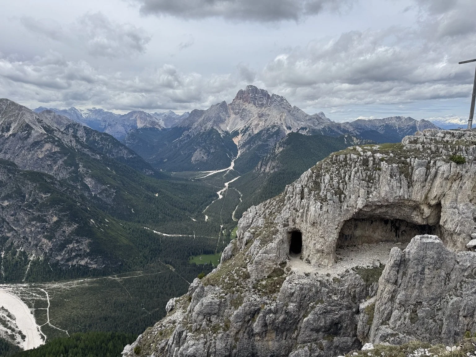 World War I tunnel openings cut into a Monte Piana cliff above the valley.
