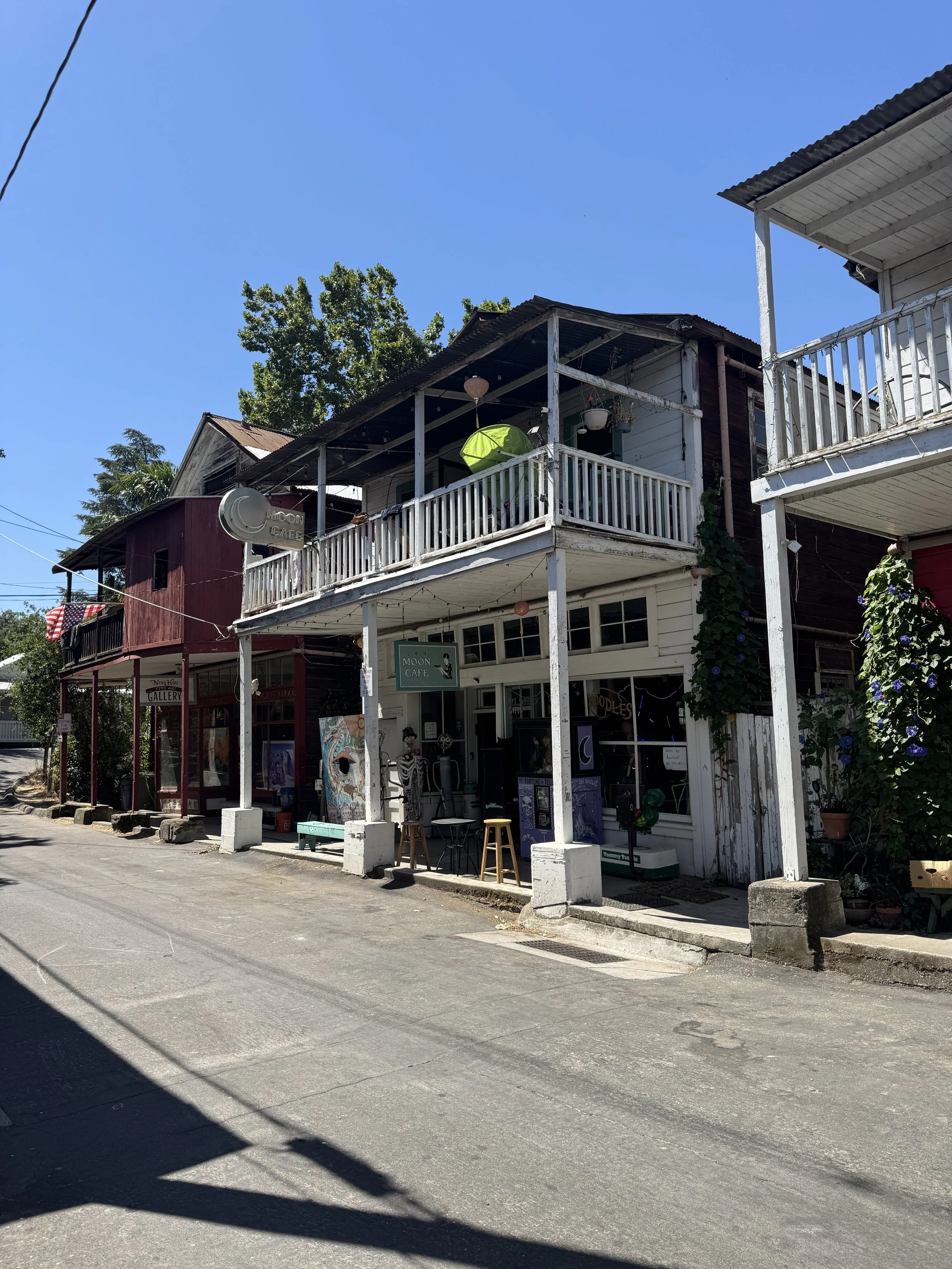 Weathered wooden storefronts and balconies along a quiet historic street in Locke, California.