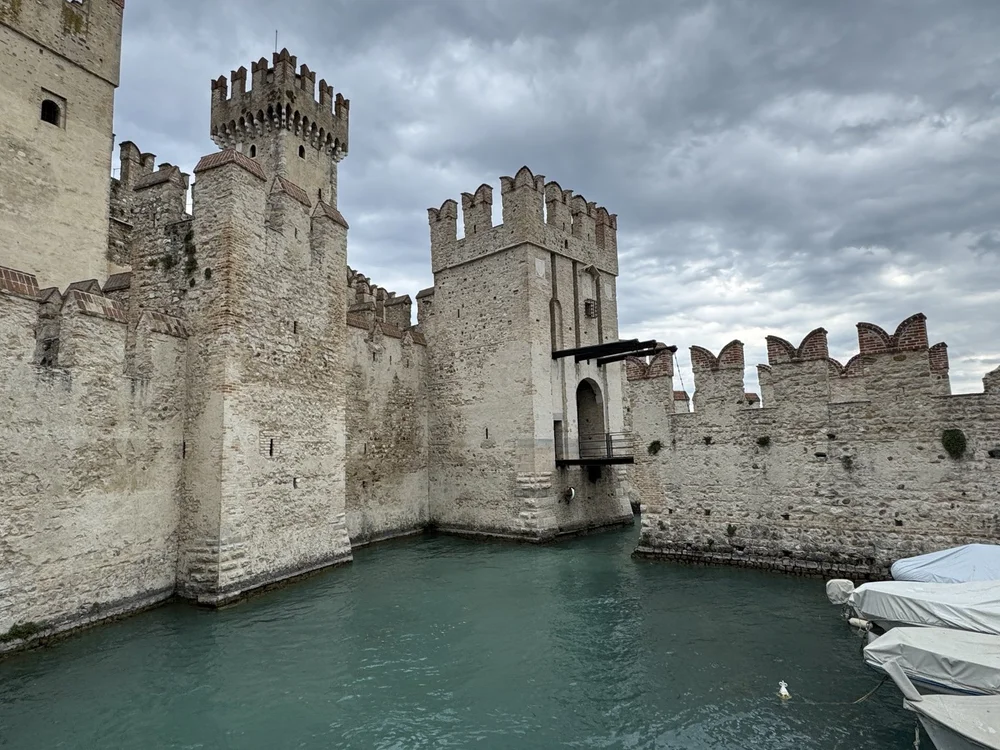 Scaliger Castle towers and fortified harbor surrounded by Lake Garda water