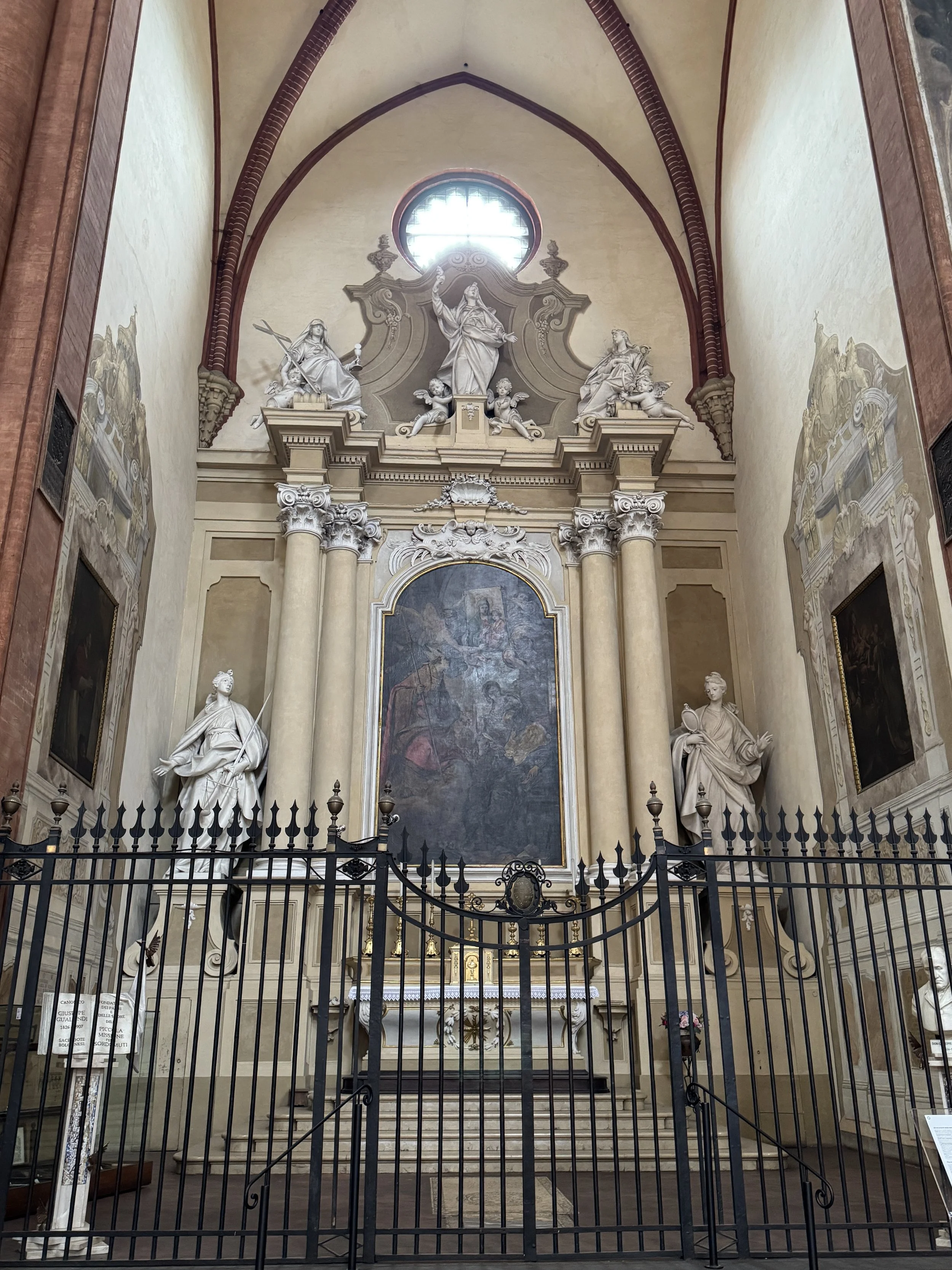 Ornate side chapel with statues and vaulted arches in Bologna.