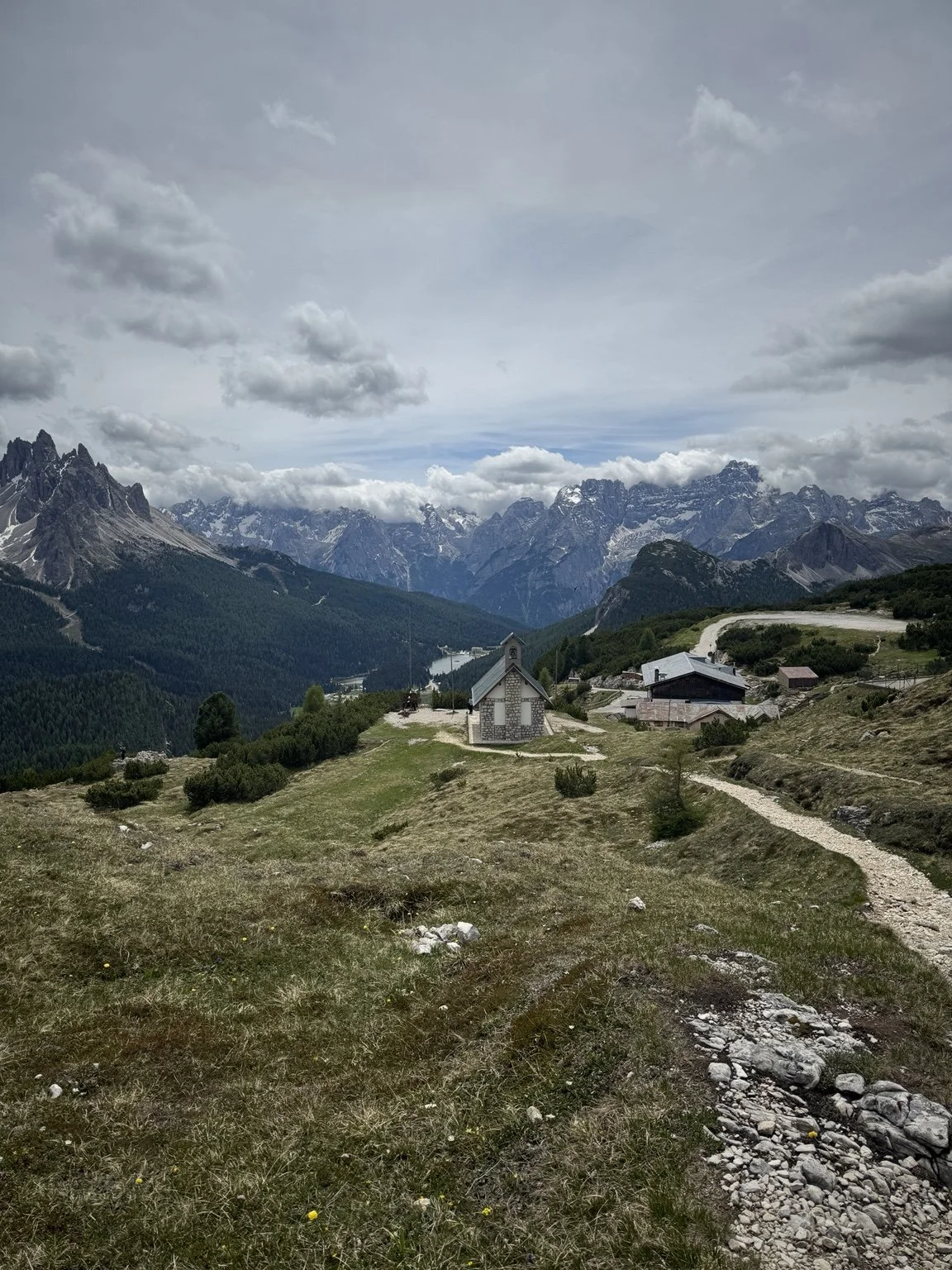 Monte Piana memorial chapel and walking paths framed by distant Dolomite mountains.