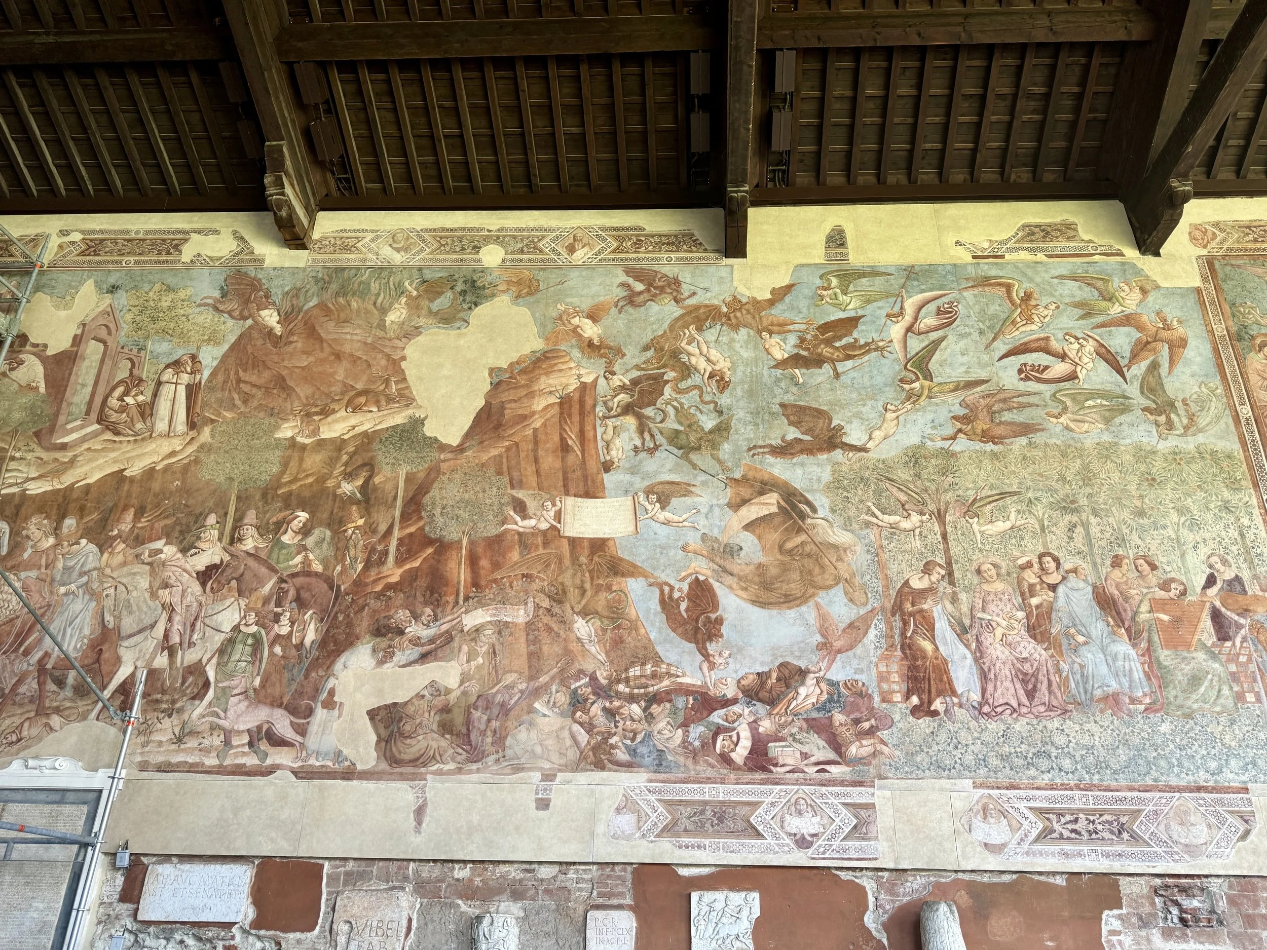 Large medieval fresco with dramatic religious scenes inside Camposanto Monumentale in Pisa.