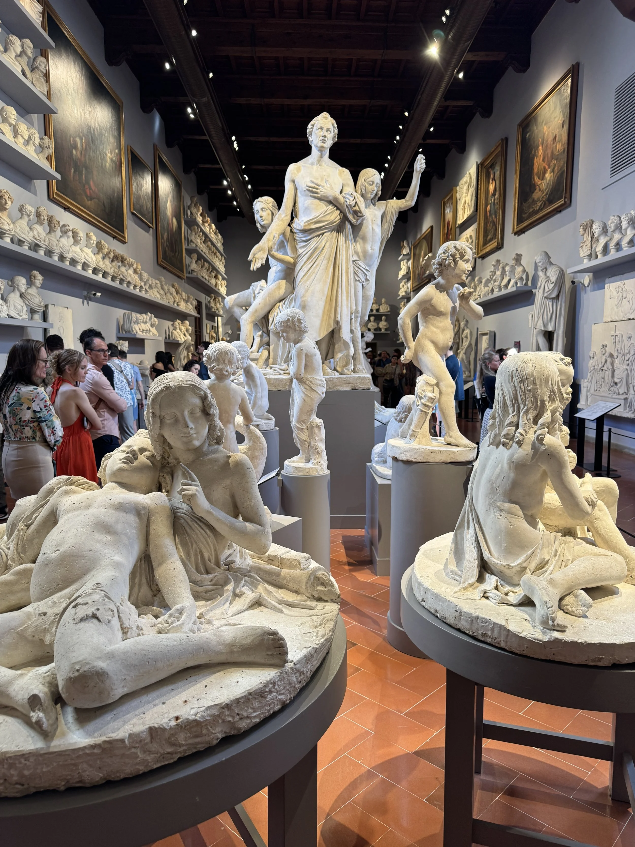 Sculpture gallery crowded with marble figures inside Florence’s Galleria dell’Accademia.