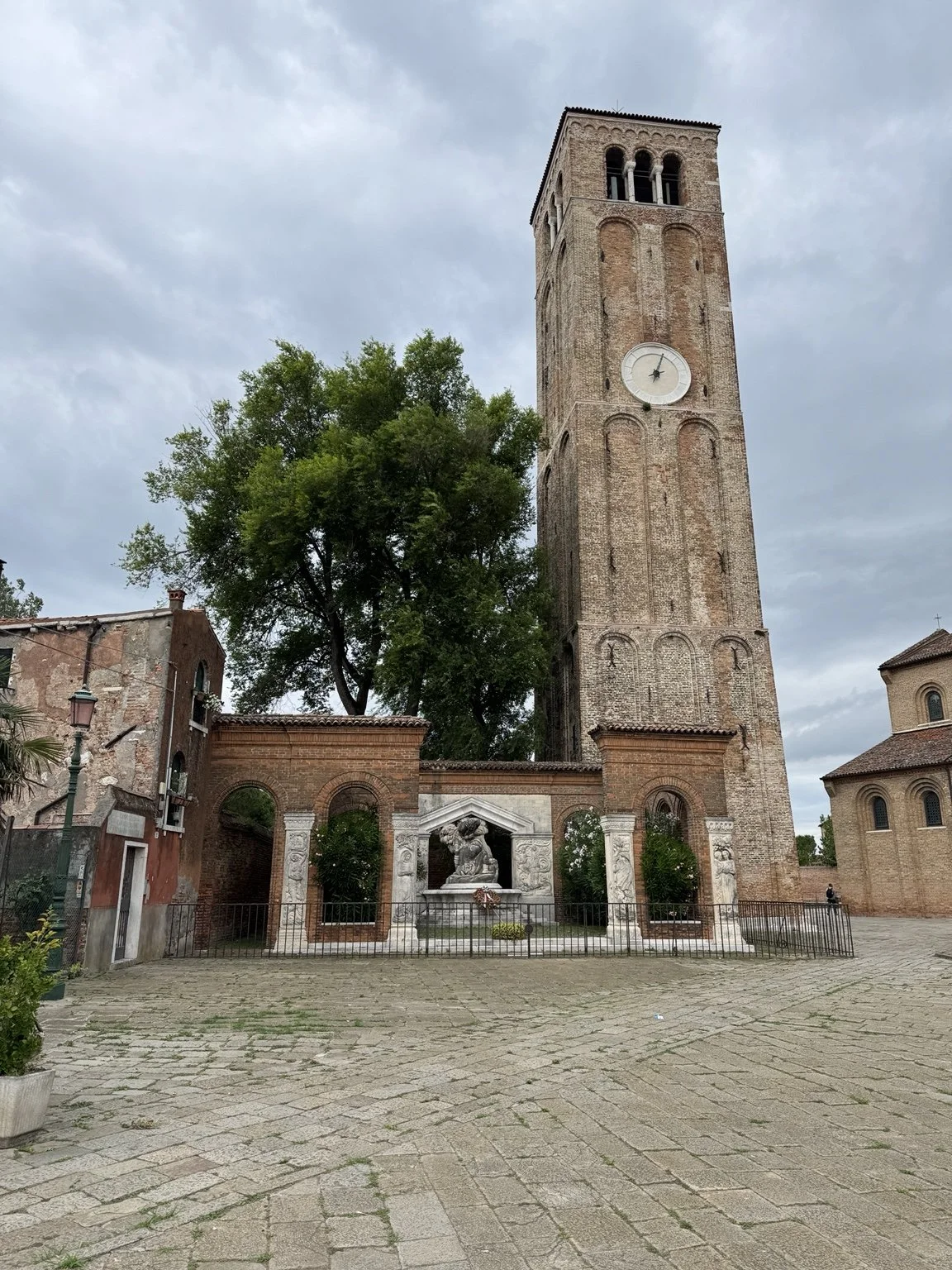 Historic brick bell tower and courtyard monument on the island of Murano.