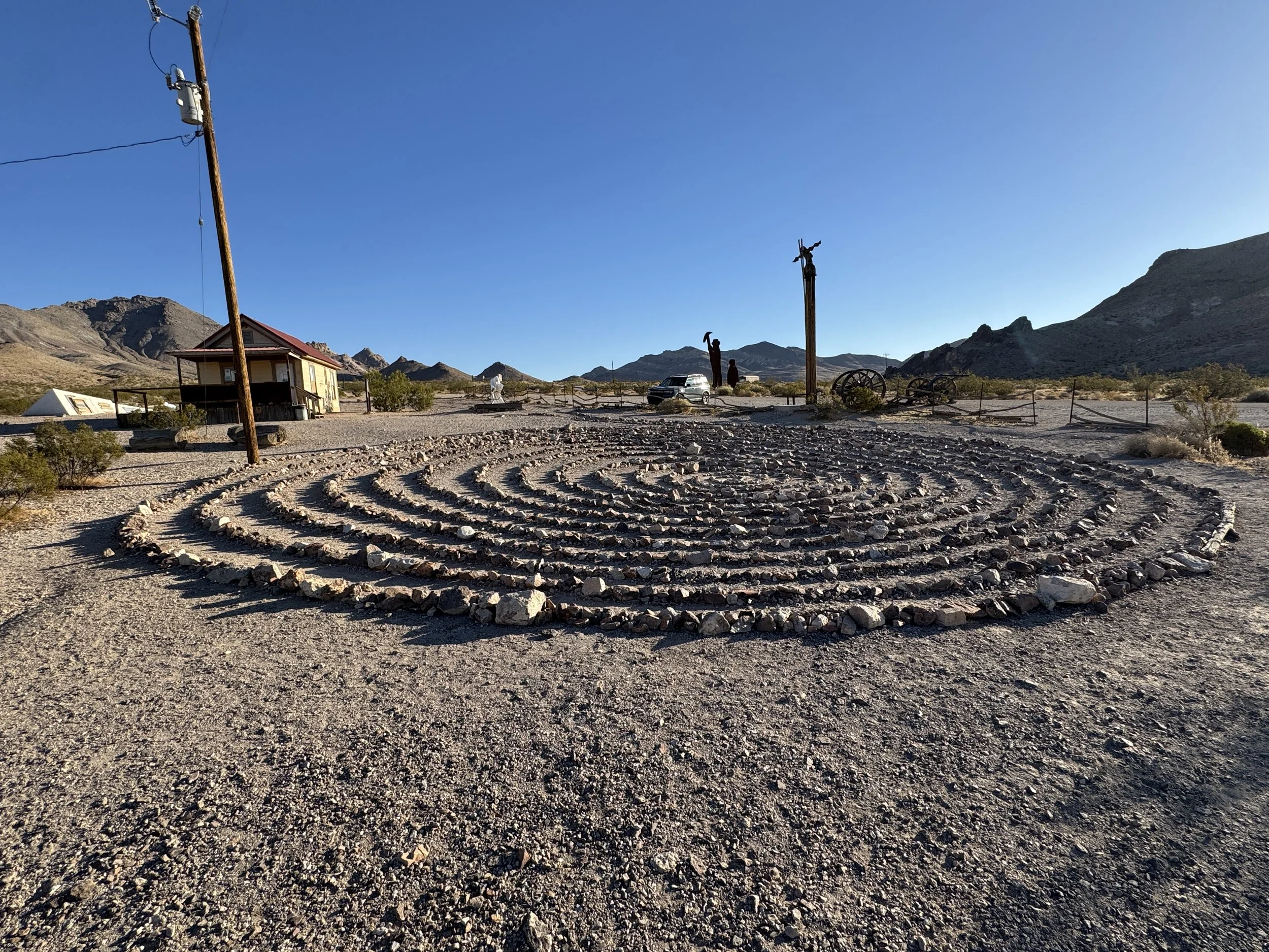Stone labyrinth surrounded by sculptures and desert mountains at the Goldwell Open Air Museum near Rhyolite, Nevada.
