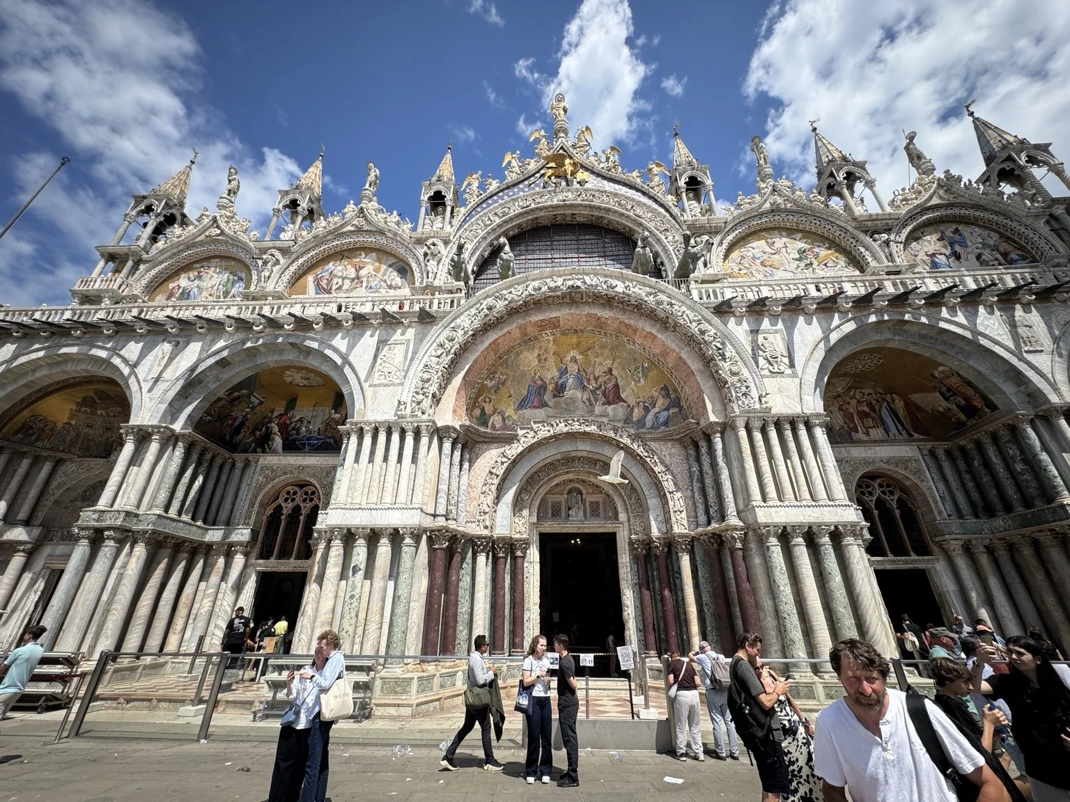 Ornate mosaic-covered façade of St. Mark’s Basilica in Piazza San Marco.