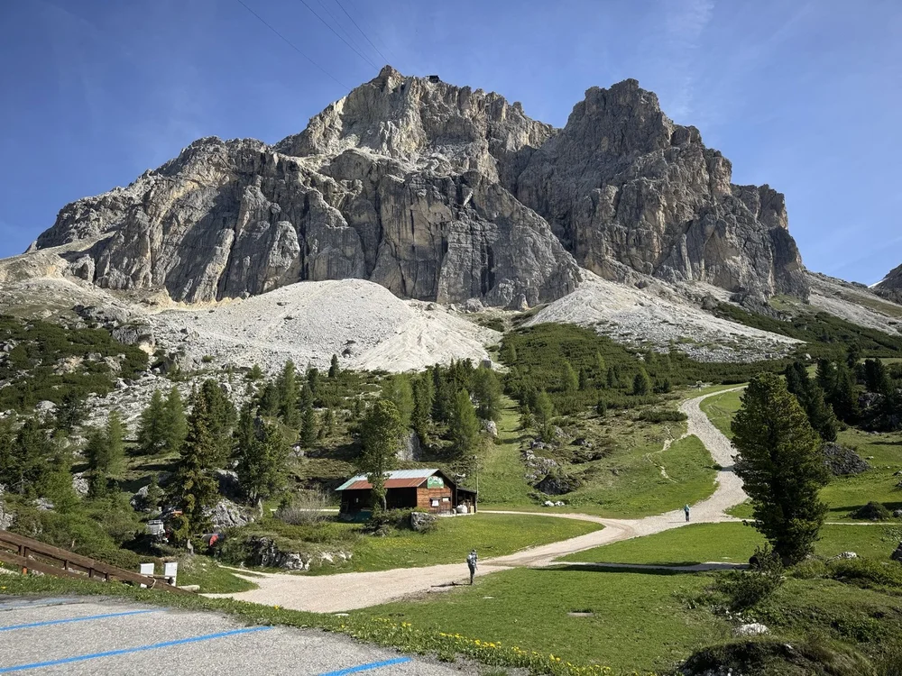 Rugged Dolomite massif rising above Alpine meadows and hiking paths near Lago di Misurina.