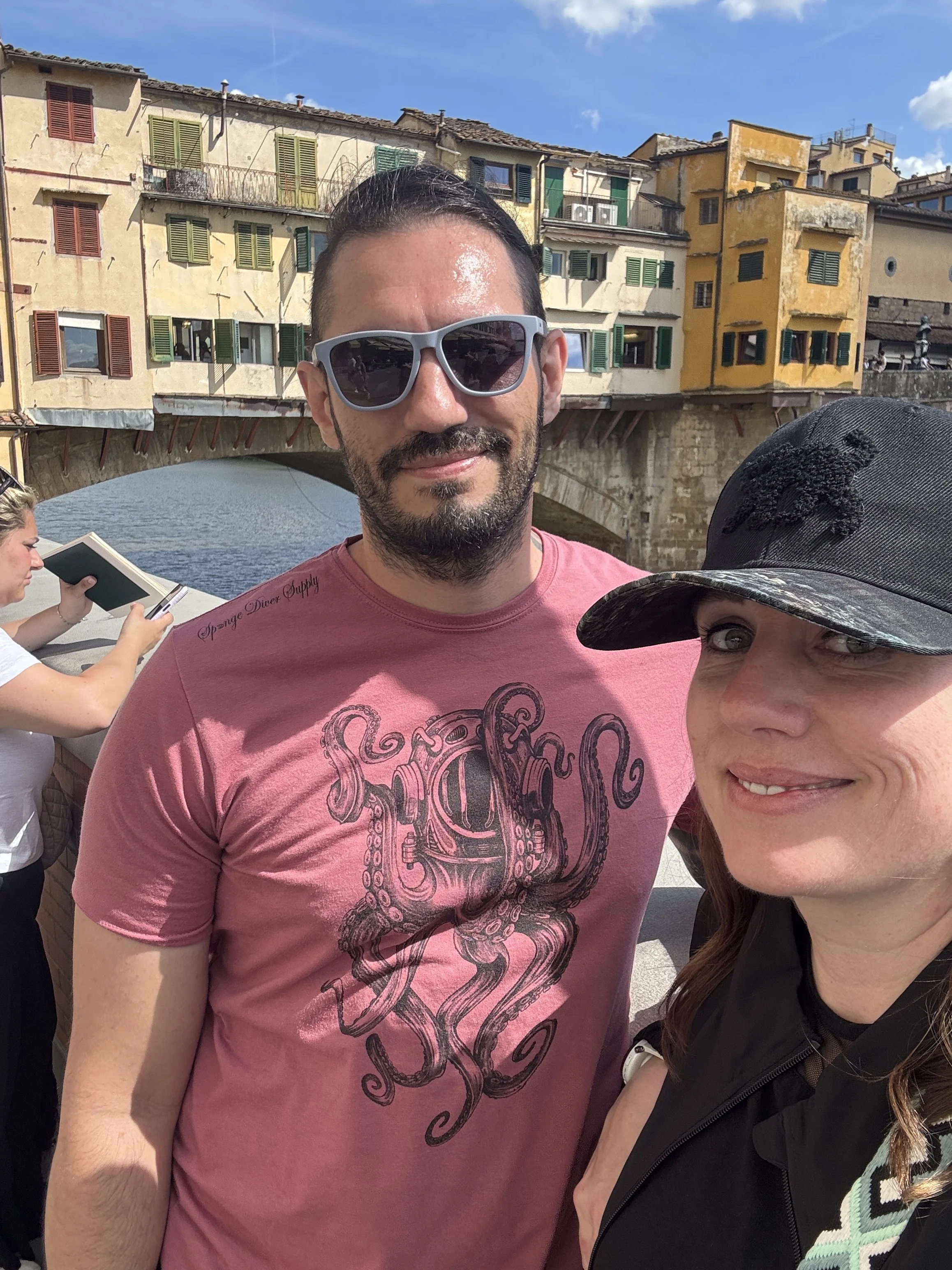 Travel selfie with Ponte Vecchio and the Arno River in the background.