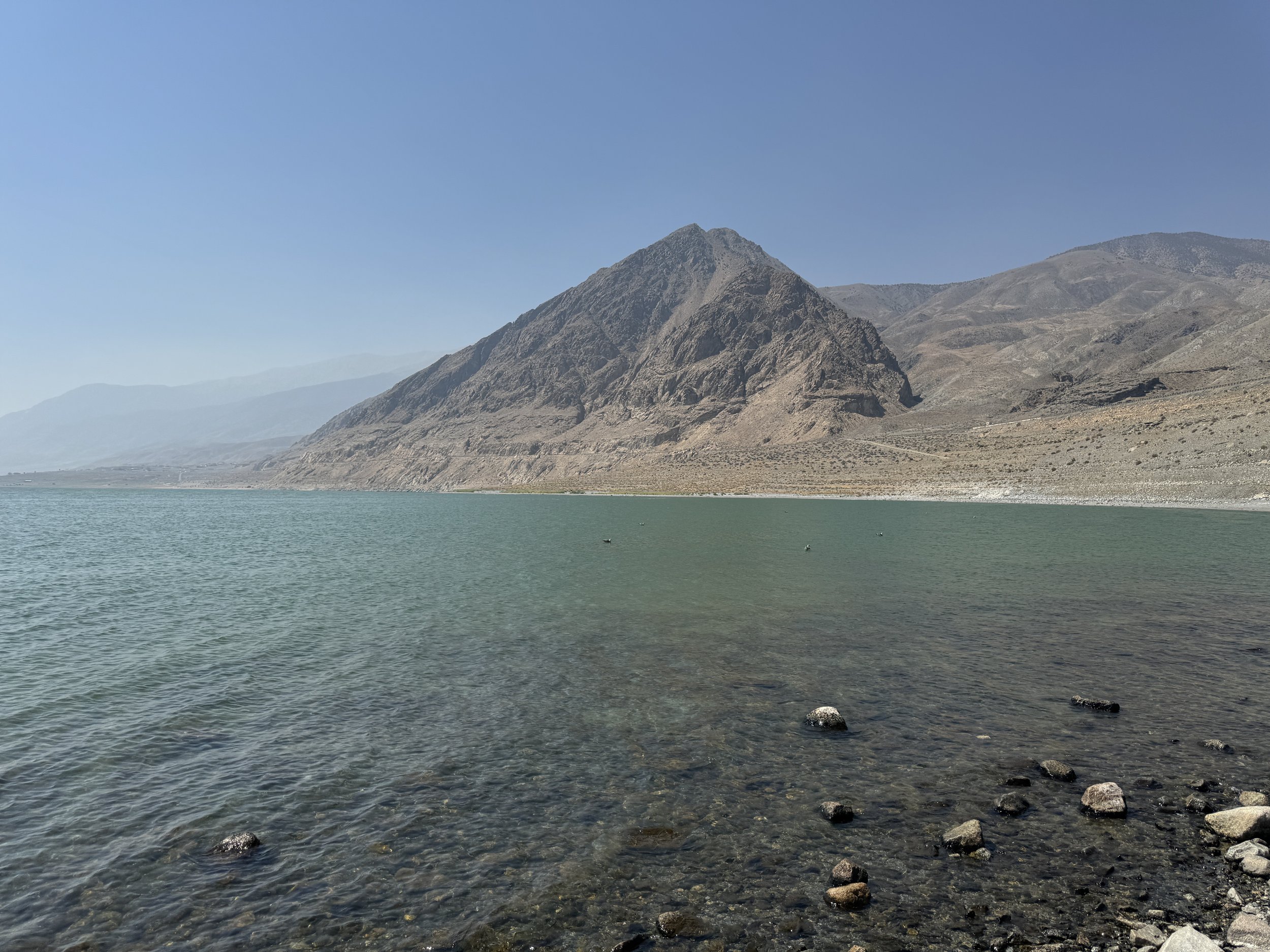 Rocky shoreline of Walker Lake with clear water and steep desert mountains in western Nevada.