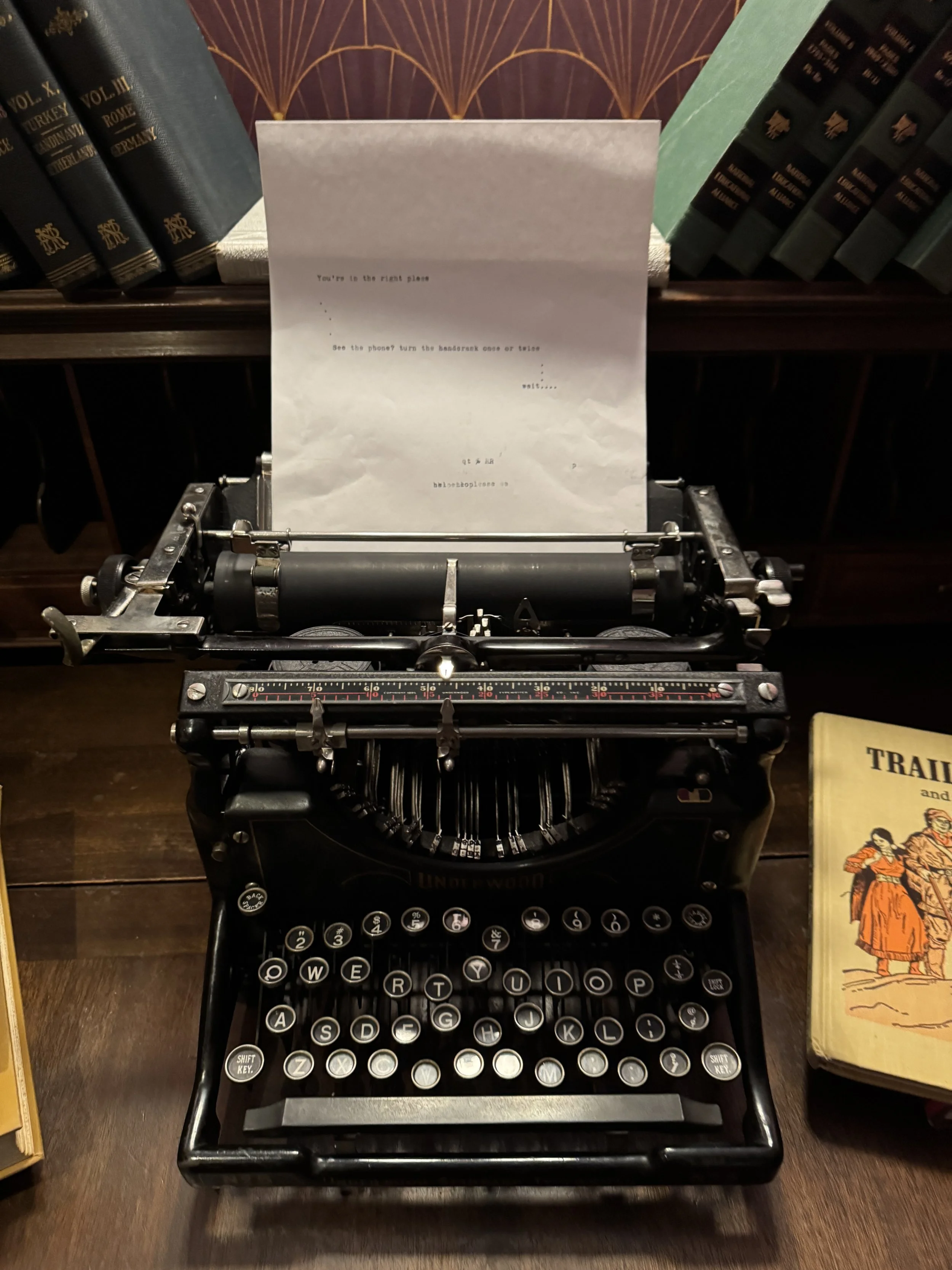 Vintage Underwood typewriter holding a typed entry clue among old books at the 1920s Bookstore speakeasy.