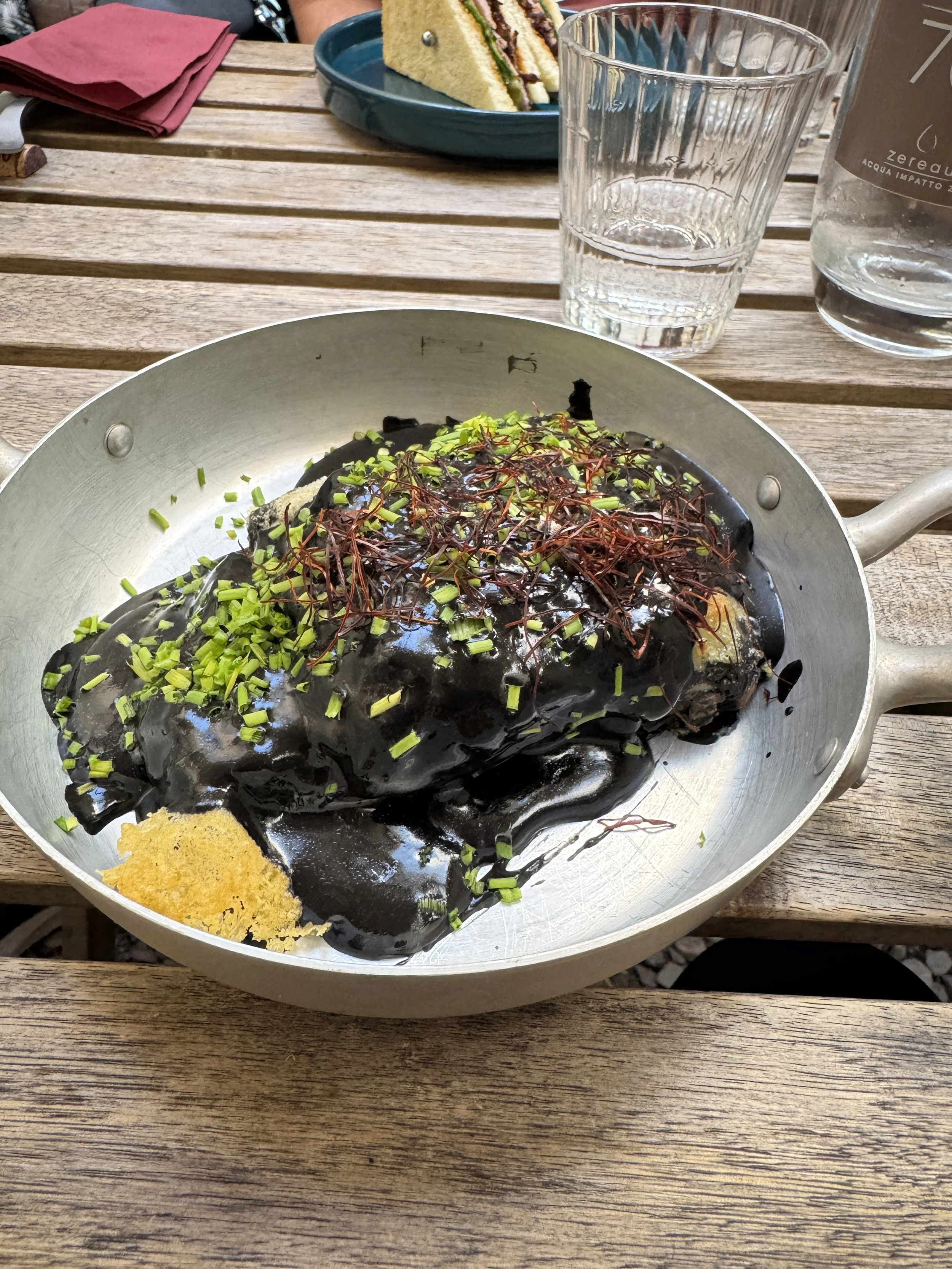 Squid-ink seafood lasagne topped with herbs at Cru in Florence.