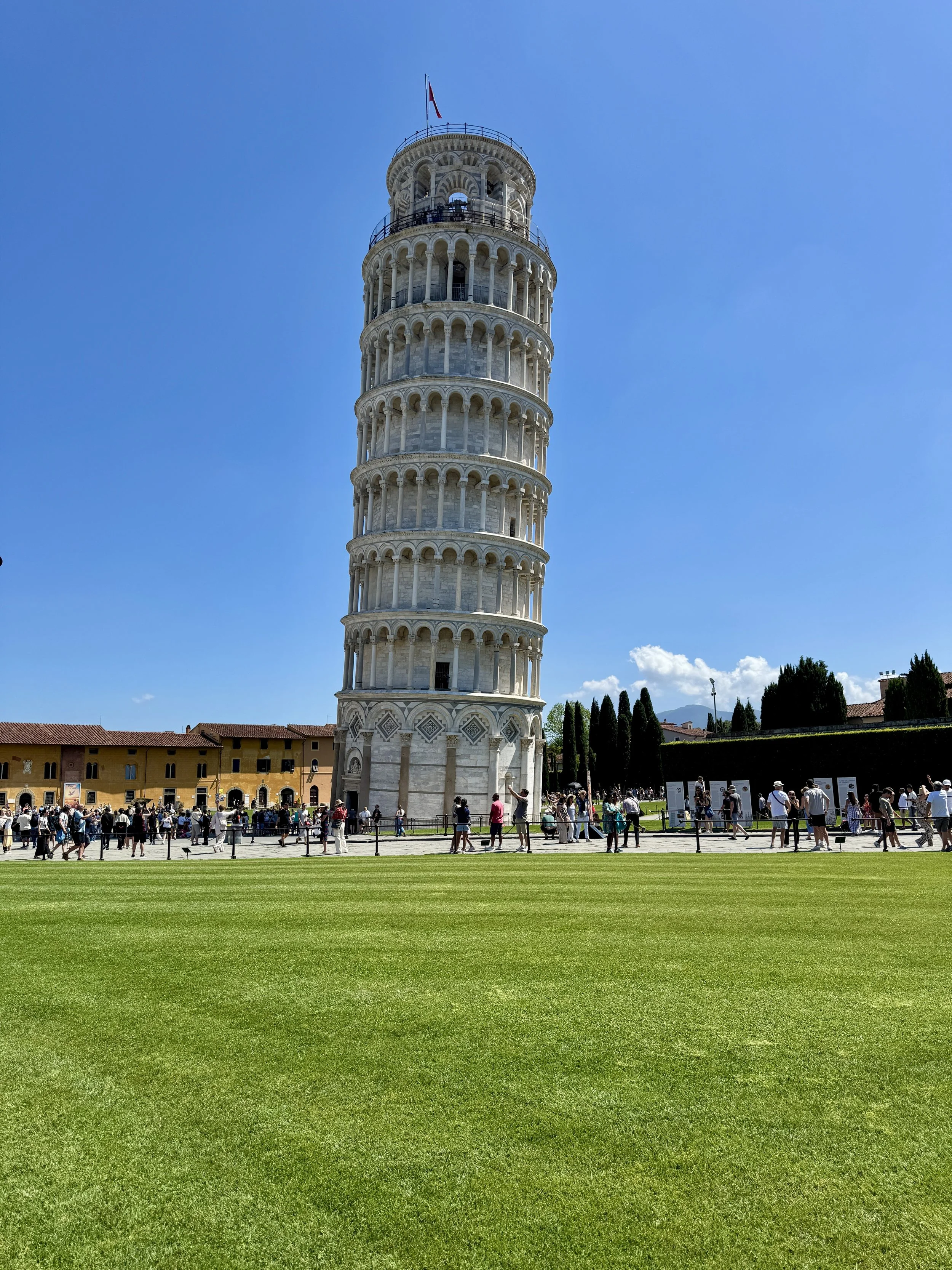 Leaning Tower of Pisa rising above the green lawn of Piazza dei Miracoli.