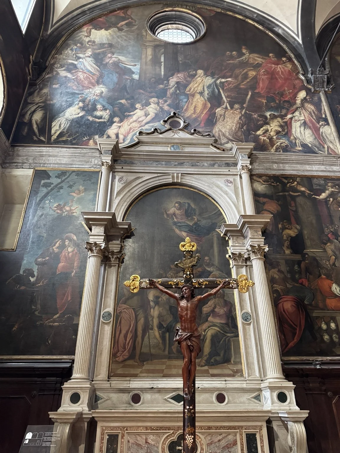 Crucifix and large religious paintings inside the Church of San Zaccaria in Venice.