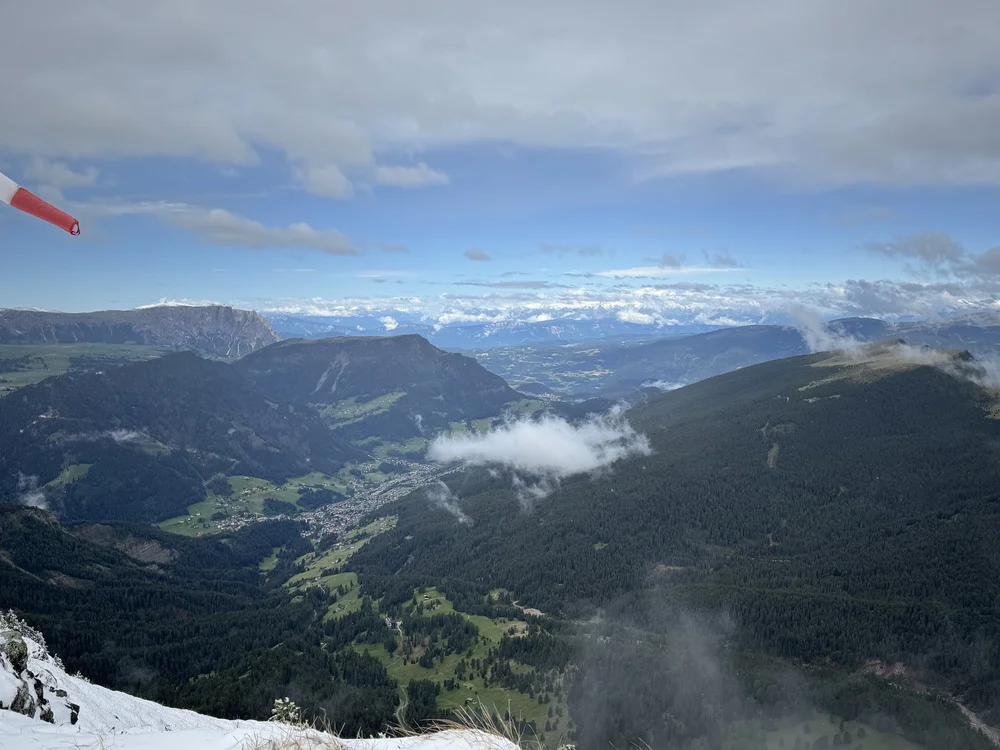 Panoramic alpine valley view from the snowy Seceda summit in the Dolomites.
