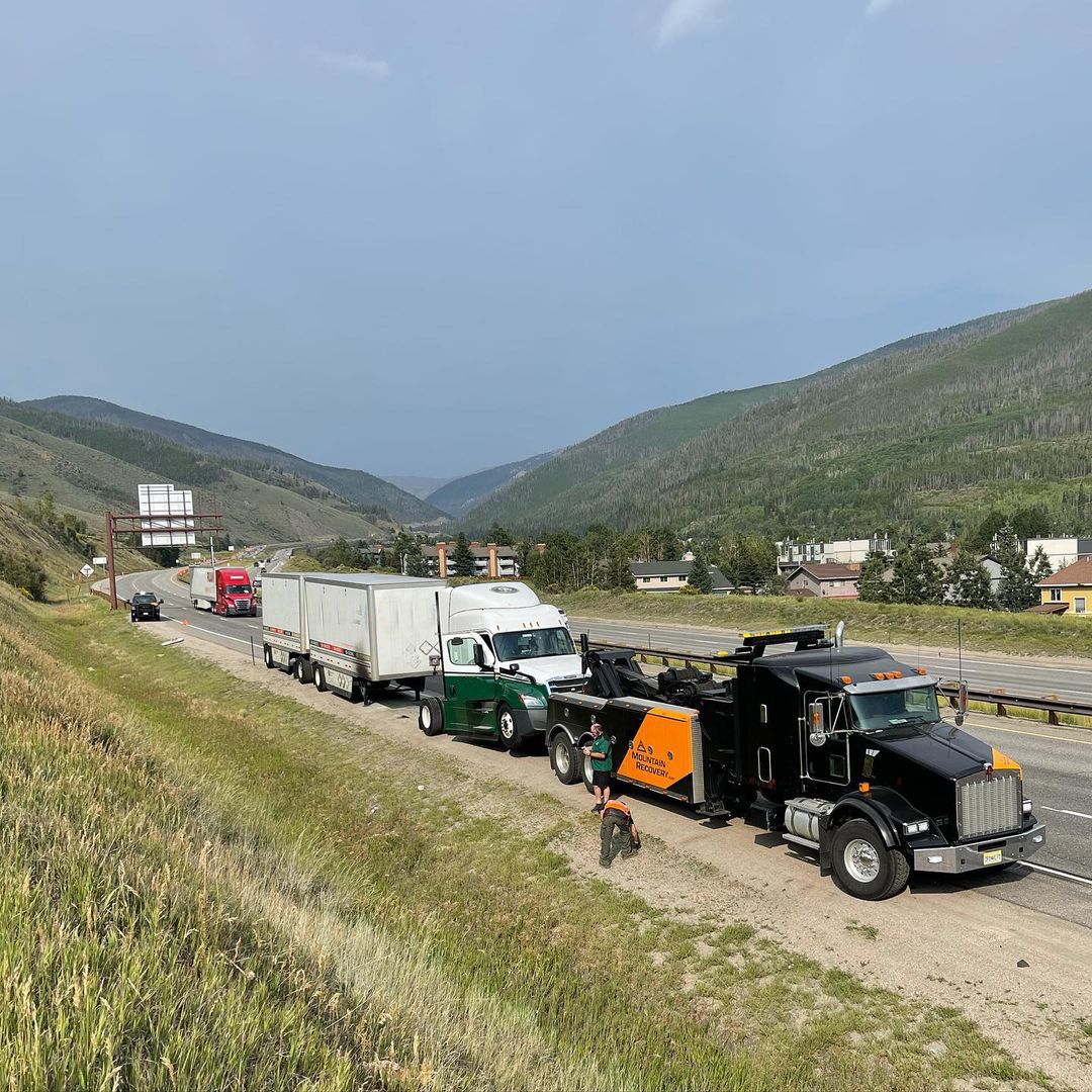 Mountain Recovery crew assisting a loaded commercial semi-truck on a Colorado highway