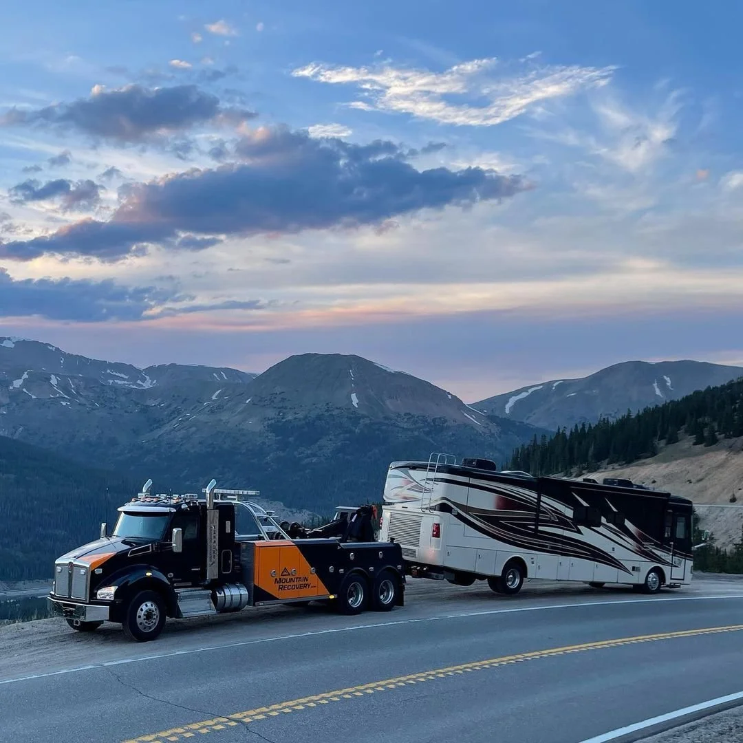 Mountain Recovery truck towing an RV and camper in Colorado