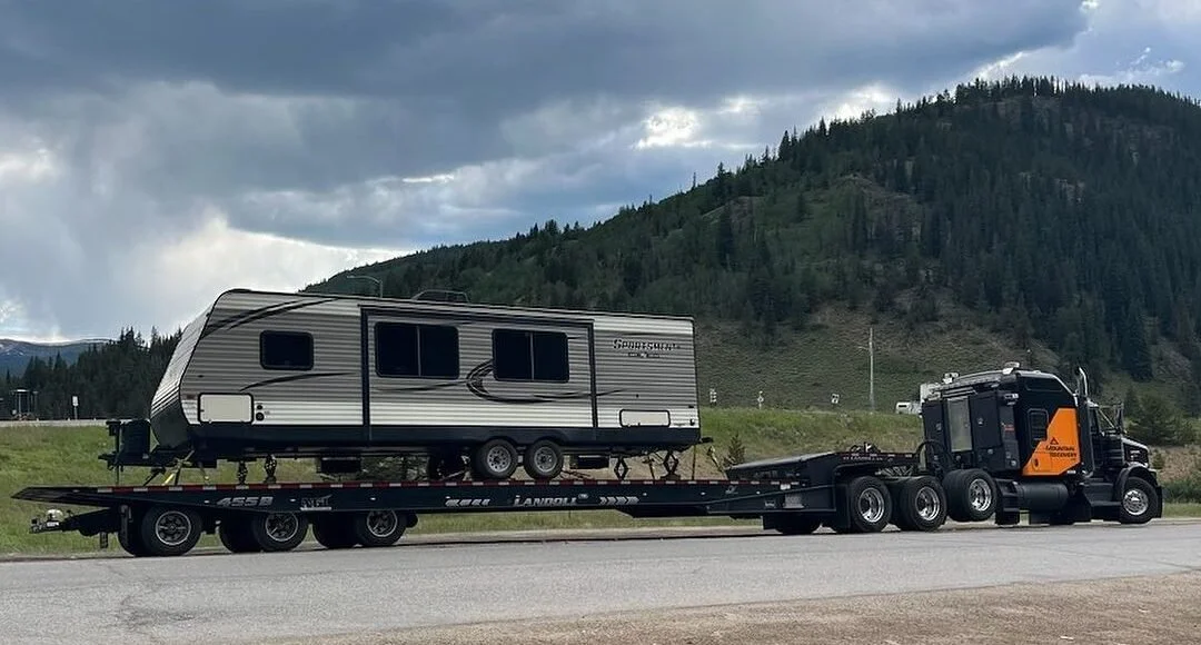 Mountain Recovery transporting a camper trailer on a specialized flatbed in Colorado