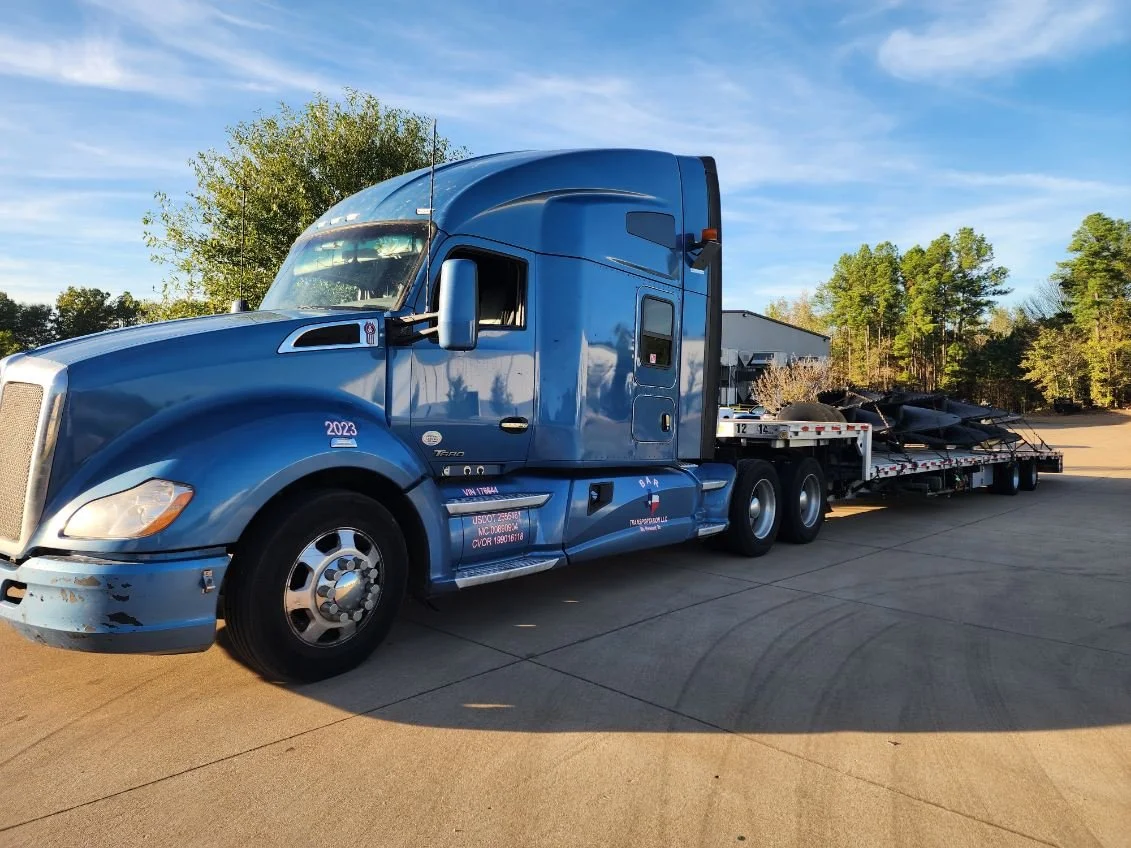 BAR Transportation blue Kenworth hauling full load of USAU military ISO containers