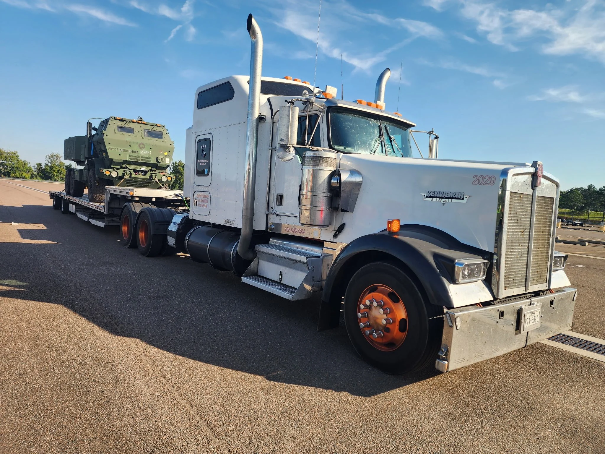 BAR Transportation white Kenworth 2029 hauling military vehicle