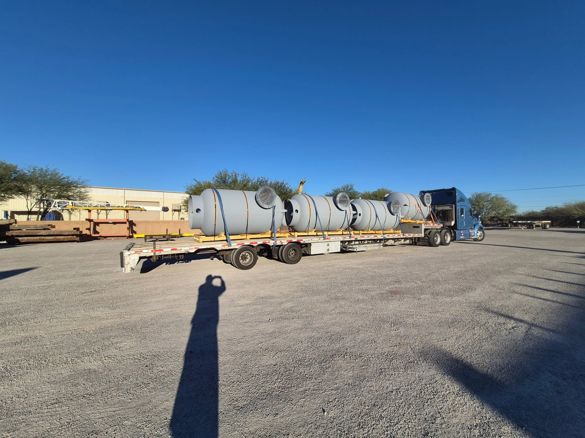 BAR Transportation blue Kenworth with military vehicles at Army depot