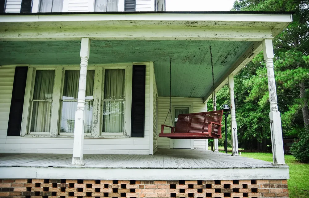 Older front porch with aging structure and worn floor