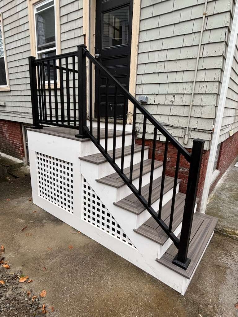 New composite stairs with black aluminum railings and lattice skirt in Somerville, MA